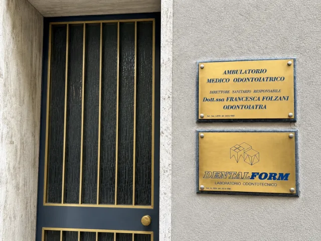 Ingresso dello Studio Dentistico Francesca Folzani a Varese, con porta d’accesso e targhe identificative dell’ambulatorio odontoiatrico e del laboratorio Dentalform.