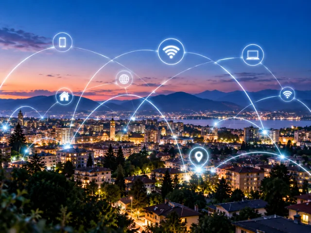Panorama di una città illuminata al tramonto con collegamenti digitali e icone Wi-Fi che rappresentano la connettività Internet e la copertura della rete mobile.