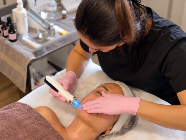 Trattamento viso presso il Centro Estetico La Ninfea a Induno Olona, con un'estetista impegnata nell'utilizzo di un dispositivo professionale per la cura della pelle.